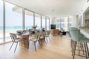 a dining room with a table and chairs and a living room at Frank Porter - Al Saadiyat Island in Abu Dhabi