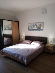 - une chambre avec un grand lit, 2 tables et un miroir dans l'établissement Apartment Maja, à Zadar