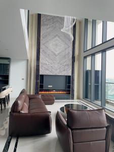 een woonkamer met 2 leren banken en een tv bij Eco Penthouse in Hanoi