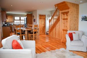 a kitchen and living room with wood paneling at Beautiful stone cottage with sea views in Sneem