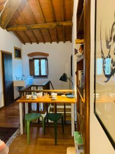 une salle à manger avec une table en bois et des chaises vertes dans l'établissement Spacious room "Ragusana" for 2 guests & child, à Donnini