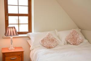 a bed with two pillows on it next to a window at Beautiful stone cottage with sea views in Sneem