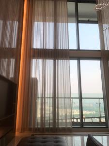 een kamer met een groot raam met witte gordijnen bij Eco Penthouse in Hanoi