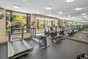 a gym with treadmills and elliptical machines and windows at Astoria Elegance by Iris Properties in Victoria