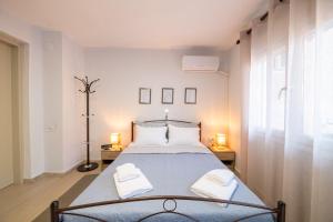 - une chambre avec un lit, deux lampes et une fenêtre dans l'établissement The Florina Park House, à Flórina