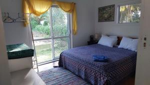 a bedroom with a bed and a large window at Barefoot Base Tupapa in Rarotonga