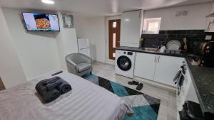 a room with a bed and a kitchen with a sink at Comfy Studio apartment with Wi-Fi and Smart TV in Leeds
