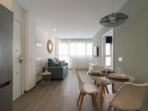 - un salon avec une table, des chaises et un canapé dans l'établissement Poseidon By CanariasGetaway, à Telde