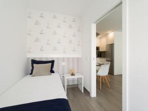 - une chambre blanche avec un lit et une table dans l'établissement Poseidon By CanariasGetaway, à Telde