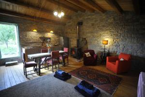 a living room with a table and chairs and a stone wall at Suite Chevalier Claudio in Agnone +32 photos