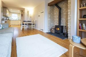 a living room with a fireplace and a living room with a couch at Mill Village 81, Trout Cottage in Somerford Keynes