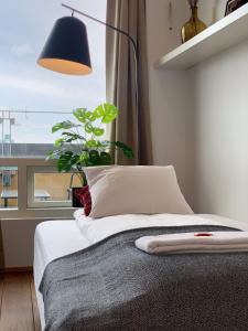 a bedroom with a bed with a lamp and a plant at Laugavegur Penthouse in Reykjavík