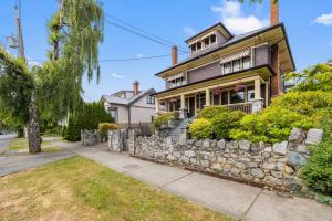 a house with a stone retaining wall and a sidewalk at Heritage Cook Street Suite in Victoria