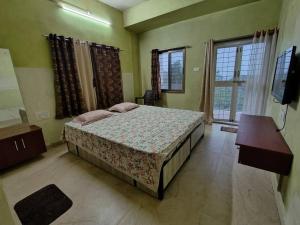 a bedroom with a bed and a tv in it at Suite with valley view Panhala Fort in Panhāla