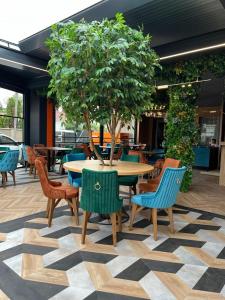 a table and chairs with a tree on a floor at Praya Boutique in Slatina