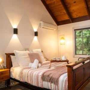 a bedroom with a bed with lights on the wall at Trawool Shed Cottages, Cafe and Restaurant in Seymour