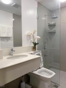 a white bathroom with a sink and a toilet at Casa de Vacaciones in Manila
