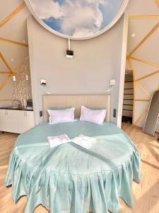 1 dormitorio con 1 cama azul grande y 2 toallas en Гостиничный комплекс Be Fine, en Besqaynar