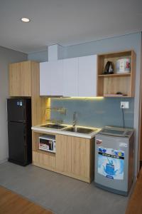 a kitchen with a sink and a refrigerator at Lancaster Lê Thánh Tôn in Ho Chi Minh City