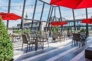 a patio with tables and chairs and red umbrellas at Ramada by Wyndham Budapest City Center in Budapest