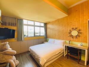 1 dormitorio con cama, TV y osito de peluche en 叁樓民宿, en Taitung