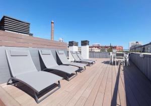 eine Reihe weißer Stühle auf einem Dach in der Unterkunft Stay U-nique Apartments Pellaires in Barcelona