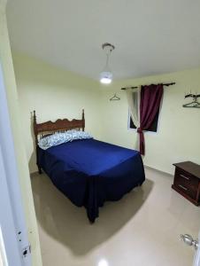 een slaapkamer met een blauw bed in een kamer bij Oviedo Pedernales, Casa Lolón 