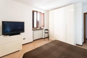 a bedroom with a flat screen tv on a dresser at Appartamento La Torre in Bastia Umbra