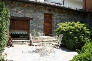 a patio with a table and chairs in front of a building at B&B Lo Tatà in Fenis
