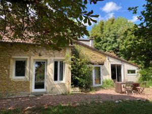 ein Steinhaus mit 2 Stühlen und einer Terrasse in der Unterkunft Maison de charme in Thil-sur-Arroux