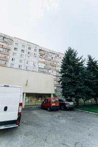 un furgone parcheggiato in un parcheggio di fronte a un edificio di Luxury Family Apart on Golovna найкраще розташування по дорозі до кордону - район ТЦ ДЕПОТ БЕЗКОНТАКТНЕ ЗАСЕЛЕННЯ a Černivci