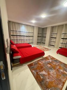 um quarto com uma cama vermelha e almofadas vermelhas em رويال للشقق الفندقيه em Almançora