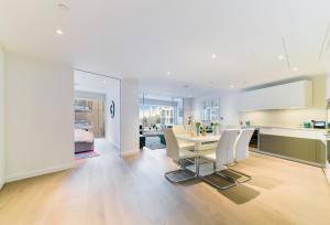 a kitchen and dining room with a table and chairs at Battersea Power Apartments in London