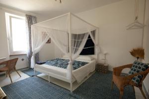 Restano的住宿－B&b Boblin blu，一间卧室配有一张天蓬床和一把椅子