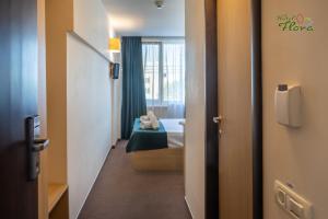 a small room with a bed and a window at Hotel Flora in Mamaia