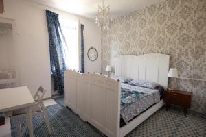 1 dormitorio con cama blanca y lámpara de araña en B&b Boblin blu, en Restano