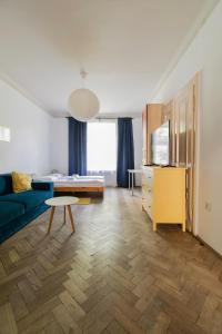 a living room with a blue couch and a table at Prestige location apartments Pijarska street in Krakow