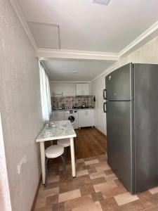 a kitchen with a table and a refrigerator at BANI tsikhisdziri in Tsikhisdziri