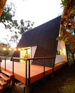 a house with a wooden deck with a black roof at Reserva Guimarães in Cambará