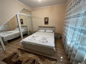 um quarto com 2 camas e um espelho grande em Къща Олеандър em Ivajlovgrad