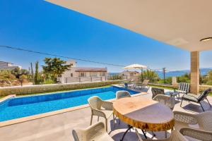 代姆雷的住宿－Luxury Sea View Villa w Pool By The Sea in Antalya，一座带游泳池和桌椅的房子