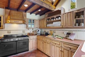 a kitchen with wooden cabinets and a black stove at Gothic Cottage in Dartmouth