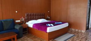 Un dormitorio con una cama y una silla azul. en Coral Garden Resort, en Neil Island