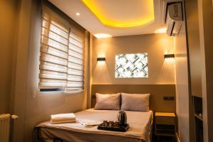 a small bedroom with a bed with a window at CK PALACE Hotel in Istanbul