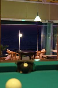een pooltafel in een kamer met een tafel en stoelen bij Ladies Beach Hotel in Kuşadası