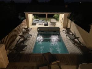 eine Aussicht über einen Pool mit Stühlen und einer Couch in der Unterkunft La villageoise in Montagne