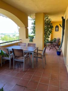 een patio met een tafel en stoelen op een veranda bij Los Naranjos Mar. in Marbella