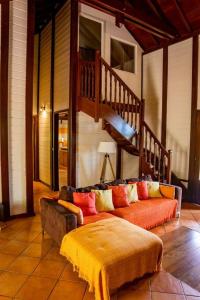 - un salon avec un canapé et un escalier dans l'établissement Villa au soleil couchant avec vue mer piscine sel, à Bouillante