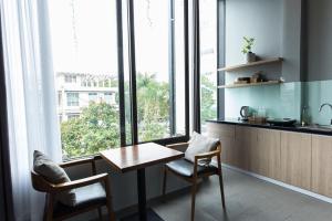 a kitchen with a table and chairs and windows at Soleil House in Hue