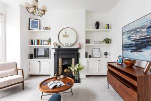 ein Wohnzimmer mit einem Kamin und einem Tisch in der Unterkunft Gorgeous Clapham Flat in London